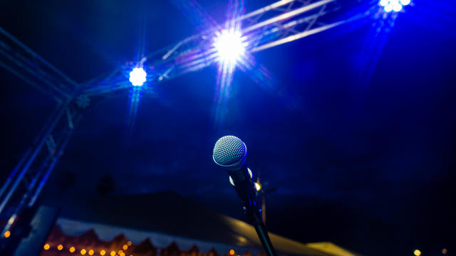Comedy or Live Music Show at Night Outdoors with Microphone and Blue Lights Nightlife 