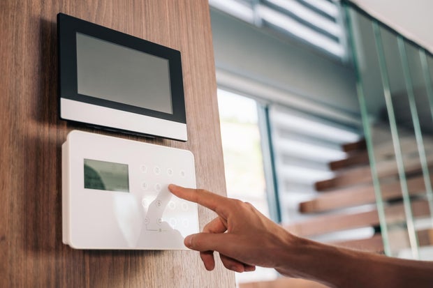 Intercom in villa with mans hand close-up.