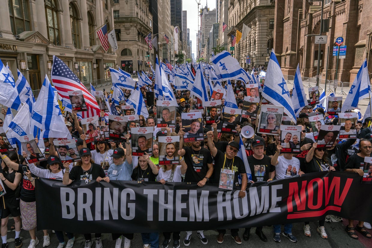 People, including the families of hostages, walk at the front holding a 'Bring them home now' sign at the the Israel Day on Fifth parade on June 2, 2024 in New York City.