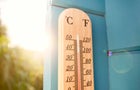 Thermometer at blue wooden wall in garden 