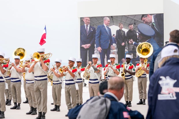 Shown in a big screen, U.S. World War II veteran Enoch Woody Woodhouse is greeted by Ukrainian President Volodymyr Zelenskyy prior to an international ceremony to mark the 80th anniversary of D-Day at Omaha Beach in Saint-Laurent-sur-Mer, Normandy, France, Thursday, June 6, 2024. World leaders are gathered Thursday in France to mark the 80th anniversary of the D-Day landings