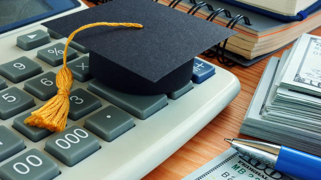 Student loan concept. Graduation cap on calculator. 