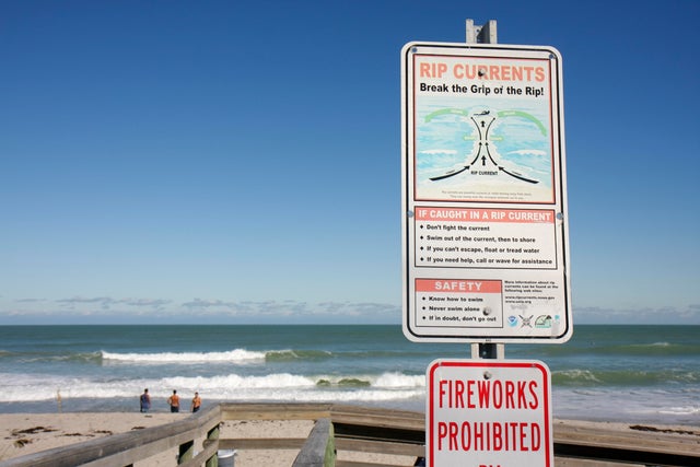 A rip current warning sign at the beach 