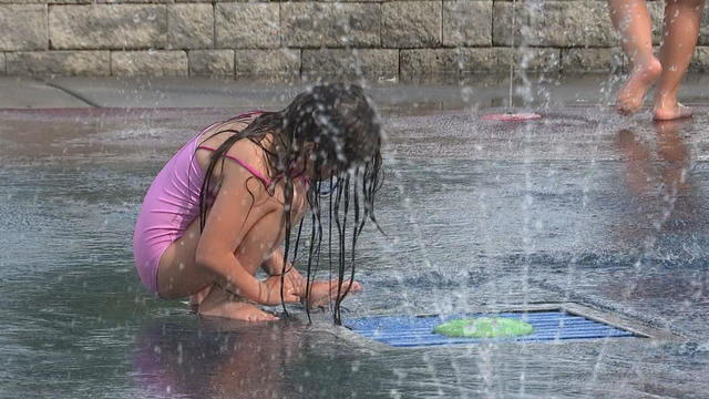 Child playing in the water during a heat wave 