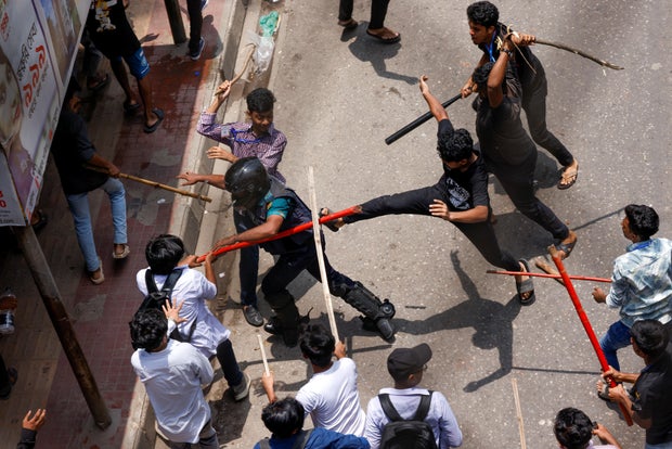 A police officer is beaten by mob during a clash between anti-quota supporters, police and Awami League supporters at the Rampura area in Dhaka