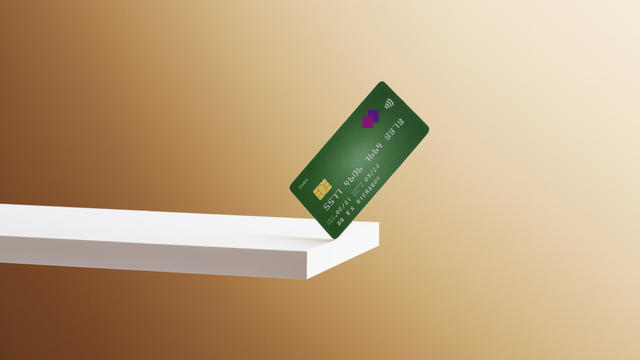 A debit card balanced on the edge of a shelf 