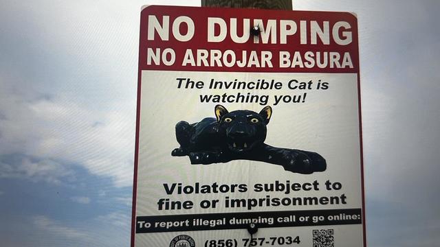 A sign that says in English and Spanish, no dumping. Violators subject to fines or imprisonment. 