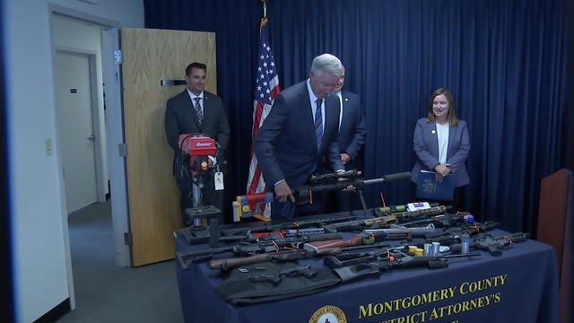 Illegal guns are displayed on a table 