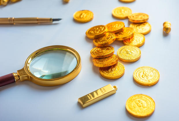 Magnifying glass and gold coins 