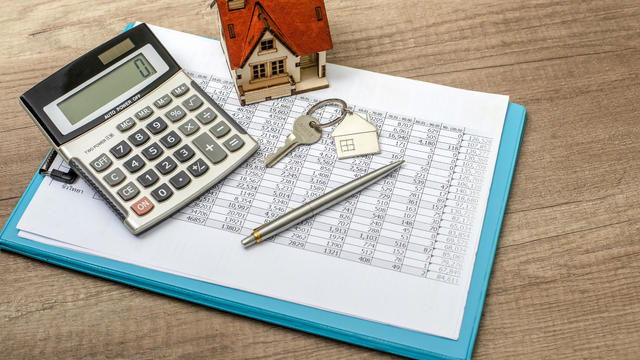 Closeup of house model and keys on wooden table 