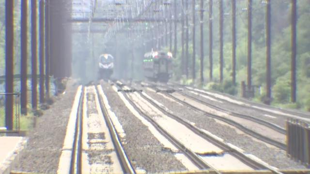 NJ Transit trains travel along tracks in extreme heat. 