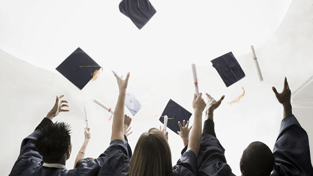 Graduates throwing mortarboards 