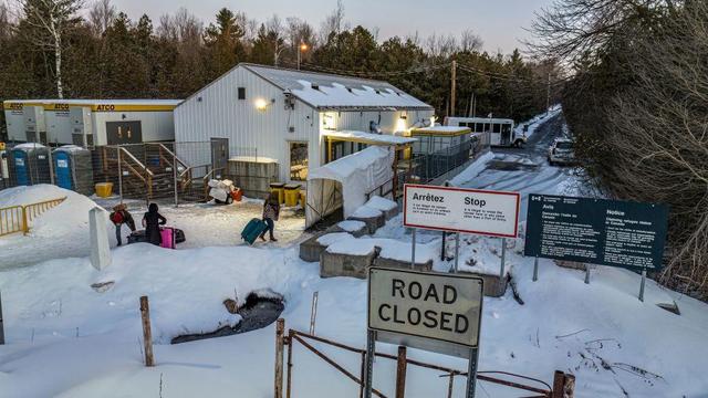 An officer speaks to migrants as they arrive at the Roxham Road border crossing in Roxham, Quebec, Canada, on March 3, 2023. 