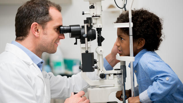 Boy getting an eye exam at the optician 