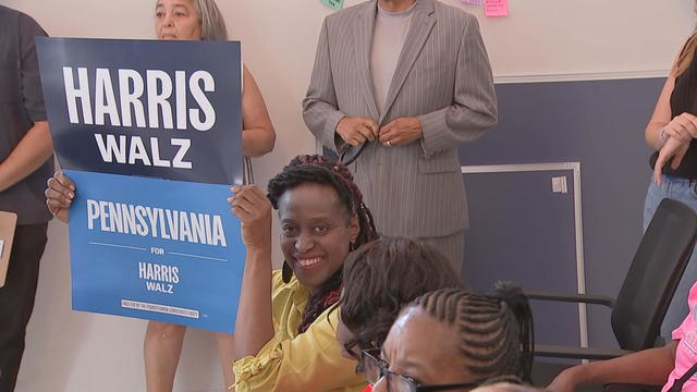 A volunteer for the Harris-Walz campaign holds up a sign during an event 