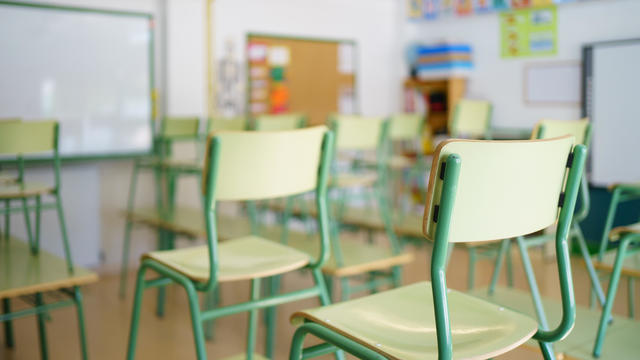 Close-up of a chair on a student's desk inside a classroom in a secondary school. 