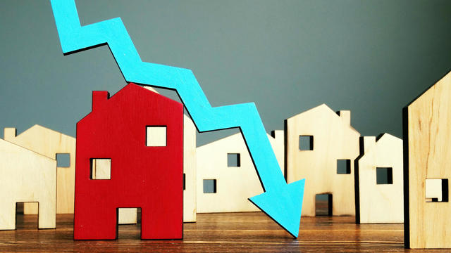 The crisis in the real estate market. Falling home value. Property and downward arrow. 