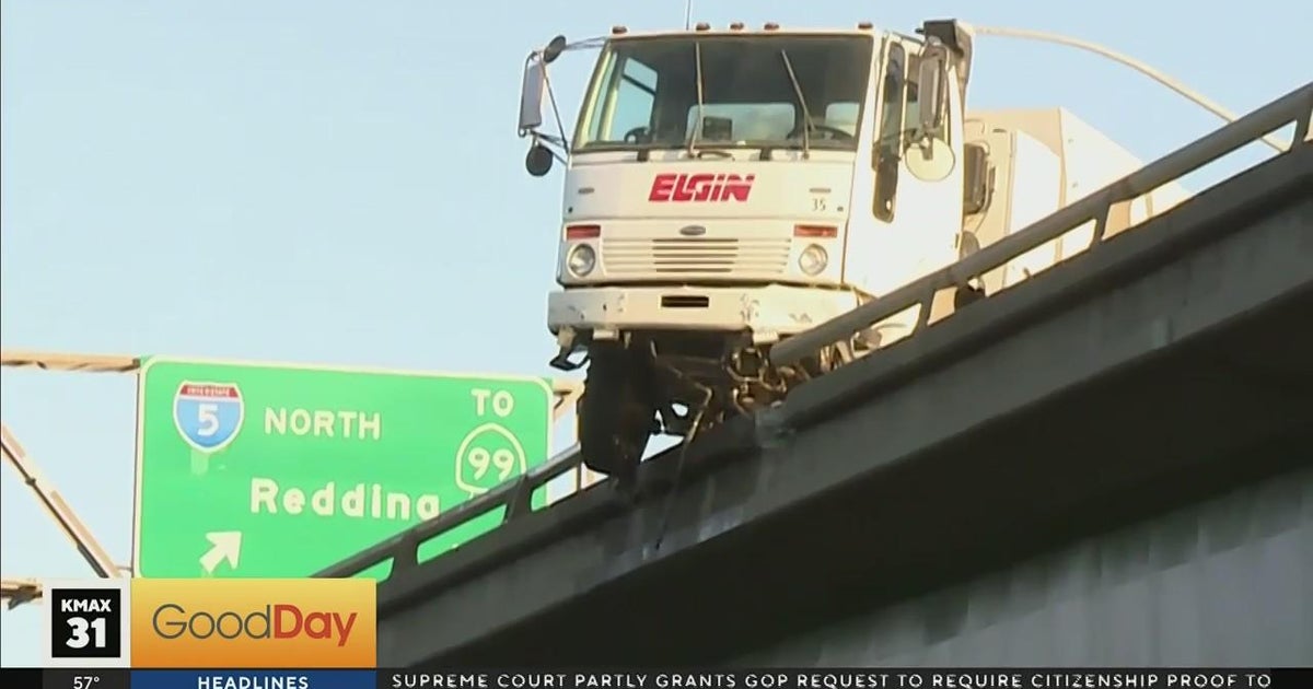 Street sweeper hangs off the side of Highway 50 in Sacramento