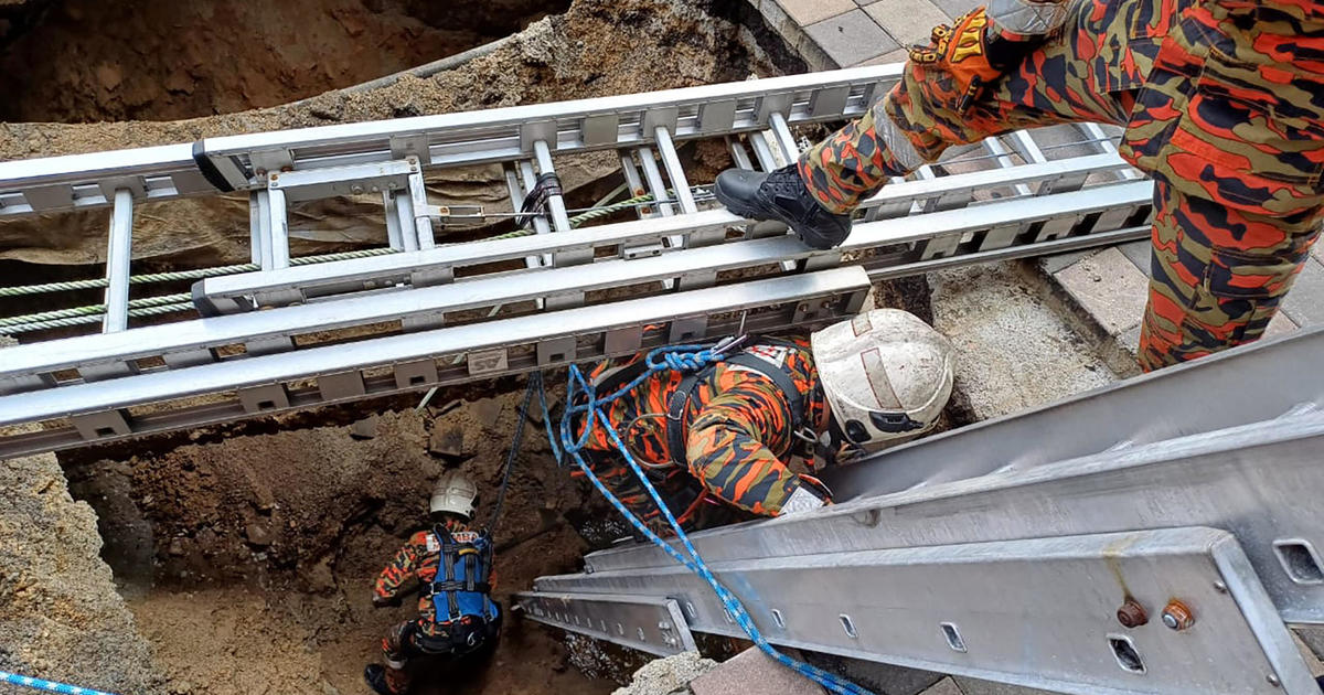 Woman buried alive in 26-foot sinkhole when pavement collapses in Malaysia