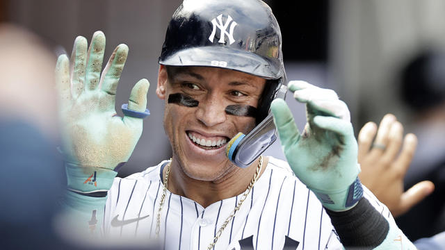 Aaron Judge #99 of the New York Yankees celebrates his seventh inning home run against the Colorado Rockies in the dugout with his teammates at Yankee Stadium on August 25, 2024 in New York City. 