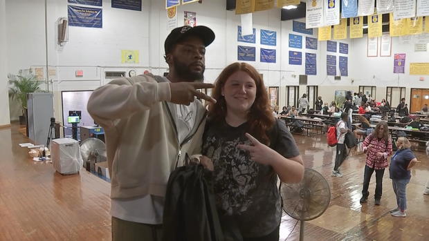 KUR poses for a photo with a student at Saul High School 