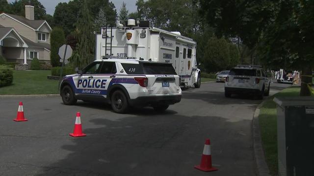 A street in Saint James blocked off by traffic cones and Suffolk County Police vehicles. 