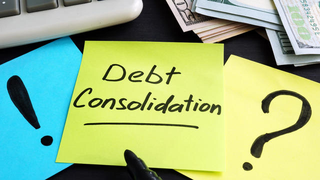 Debt consolidation written by hand and money. 