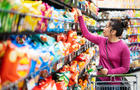 woman shopping in supermarket snack food aisle 