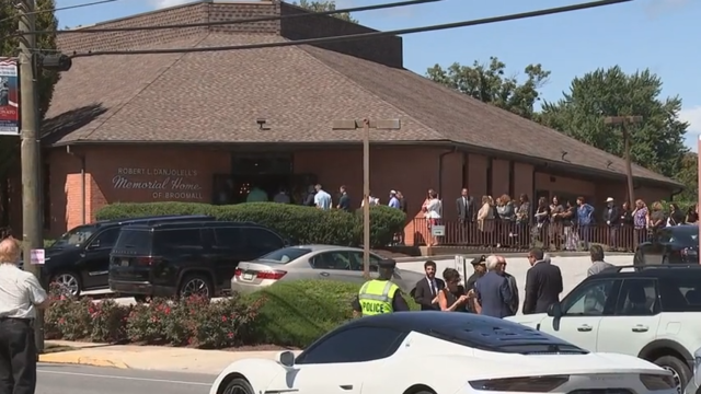 A line of people forms outside the funeral home 