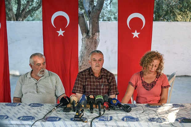 Mehmet Suat Eygi (C) father of Turkish-American activist Aysenur Ezgi Eygi, who was shot dead in the West Bank, sits between her uncle Yilmaz Eygi (L) and her cousin Bahar Tkk, as he speaks to media near the house of her grandfather in the Didim district of Aydin, Turkey