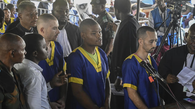 From left, Tyler Thompson Jr., Marcel Malanga and Benjamin Reuben Zalman-Polun, all American citizens, face the court in Kinshasa with 52 other defendants on June 7, 2024, accused of playing a role in an attempted coup in Congo. 