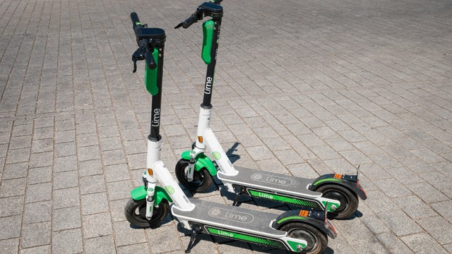 Electric scooter , escooter or e-scooter of the ride sharing company LIME on sidewalk 