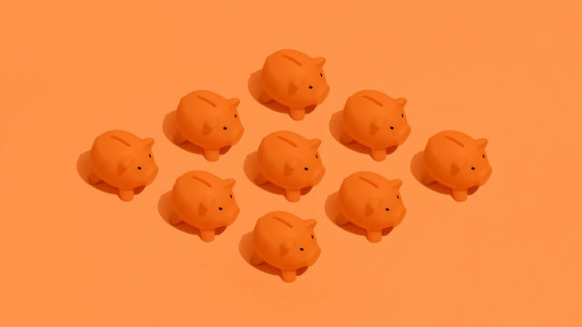 Nine Orange Piggy Banks On Orange Background 