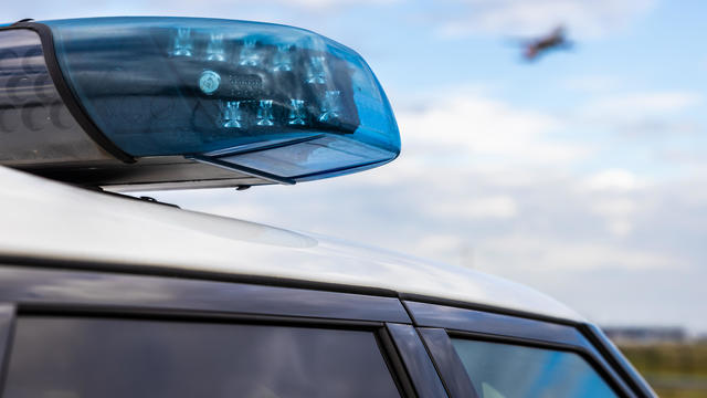 Police light on a car with passenger aircraft in the sky 