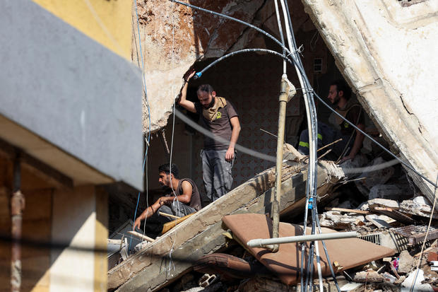 People gather near the site of an Israeli strike in Beirut's southern suburbs 