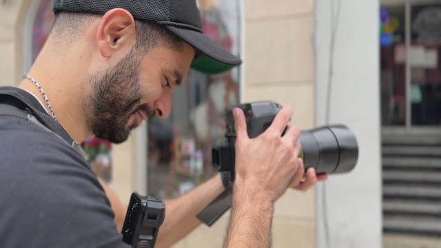 South Street Sam looks at his camera while taking a portrait on South Street 