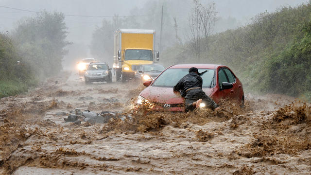 A resident helps free a stranded car as Tropical Storm Helene strikes Boone, North Carolina 