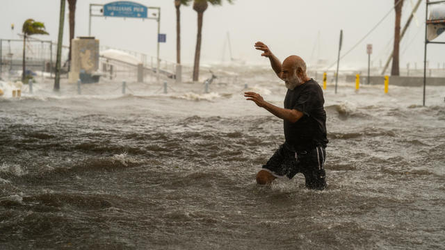 A man crosses a storm surge flooded area on the coast of Gulfport, Florida, as Hurricane Helene passed through the Gulf of Mexico to the west on Sept. 26, 2024. 