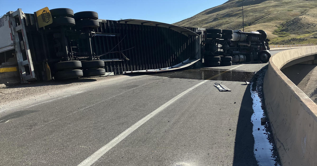 After rollover, half of the detergent leaks, trailer hangs on overpass near Denver