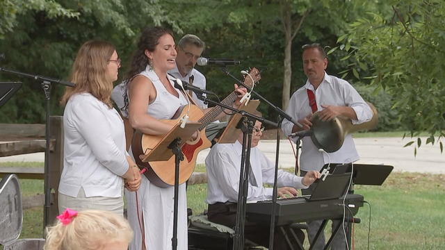 Singers and musicians perform during an outdoor service 