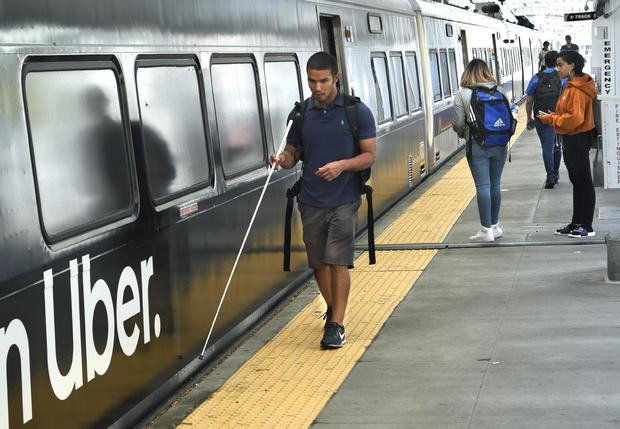 A blind man catches a train in Denver, Colorado 