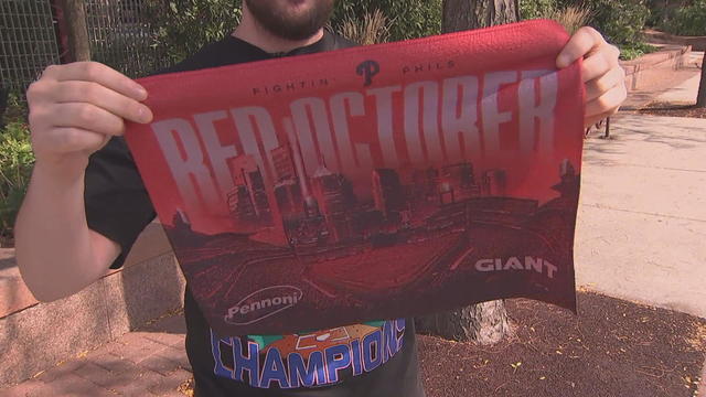 A fan holds up a red rally towel that says Red October 