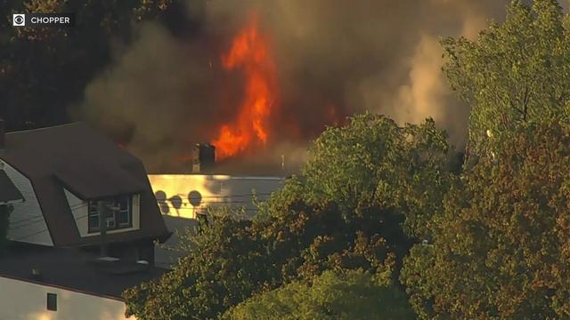 Flames shoot from the roof of a home. 