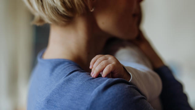 Close up of mother holding and cuddling her baby. 