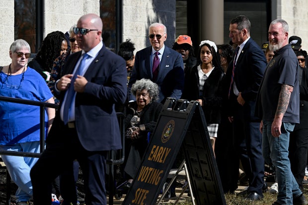 President Biden helps a woman in a wheelchair as he arrives to vote in the 2024 presidential election, in New Castle, Delaware, Oct. 28, 2024.