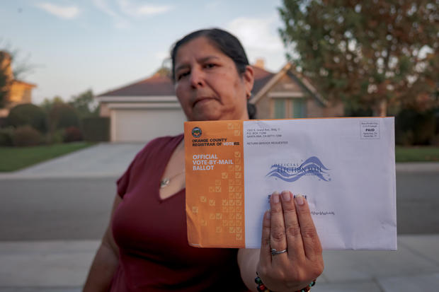 A woman seen holding an Official Vote-By-Mail Ballot. Early 