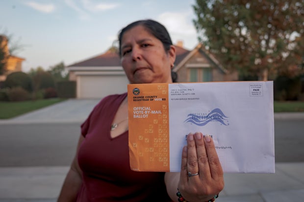 A woman seen holding an Official Vote-By-Mail Ballot. Early