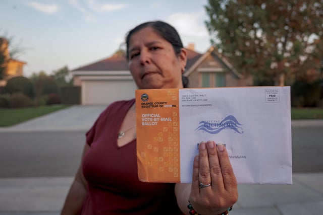 A woman seen holding an Official Vote-By-Mail Ballot. Early 