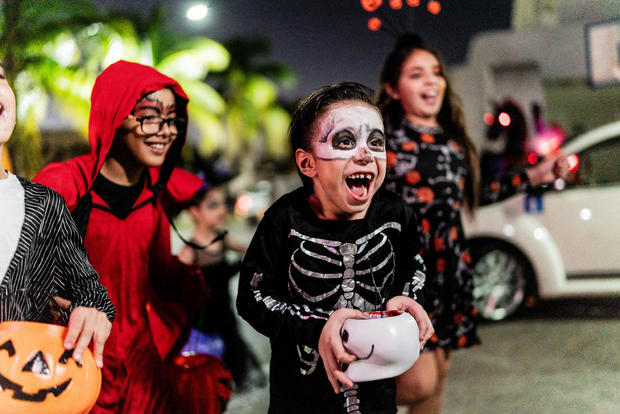 Children walking in the city picking up candy on Halloween 