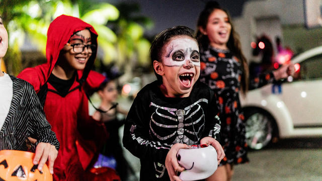 Children walking in the city picking up candy on Halloween 